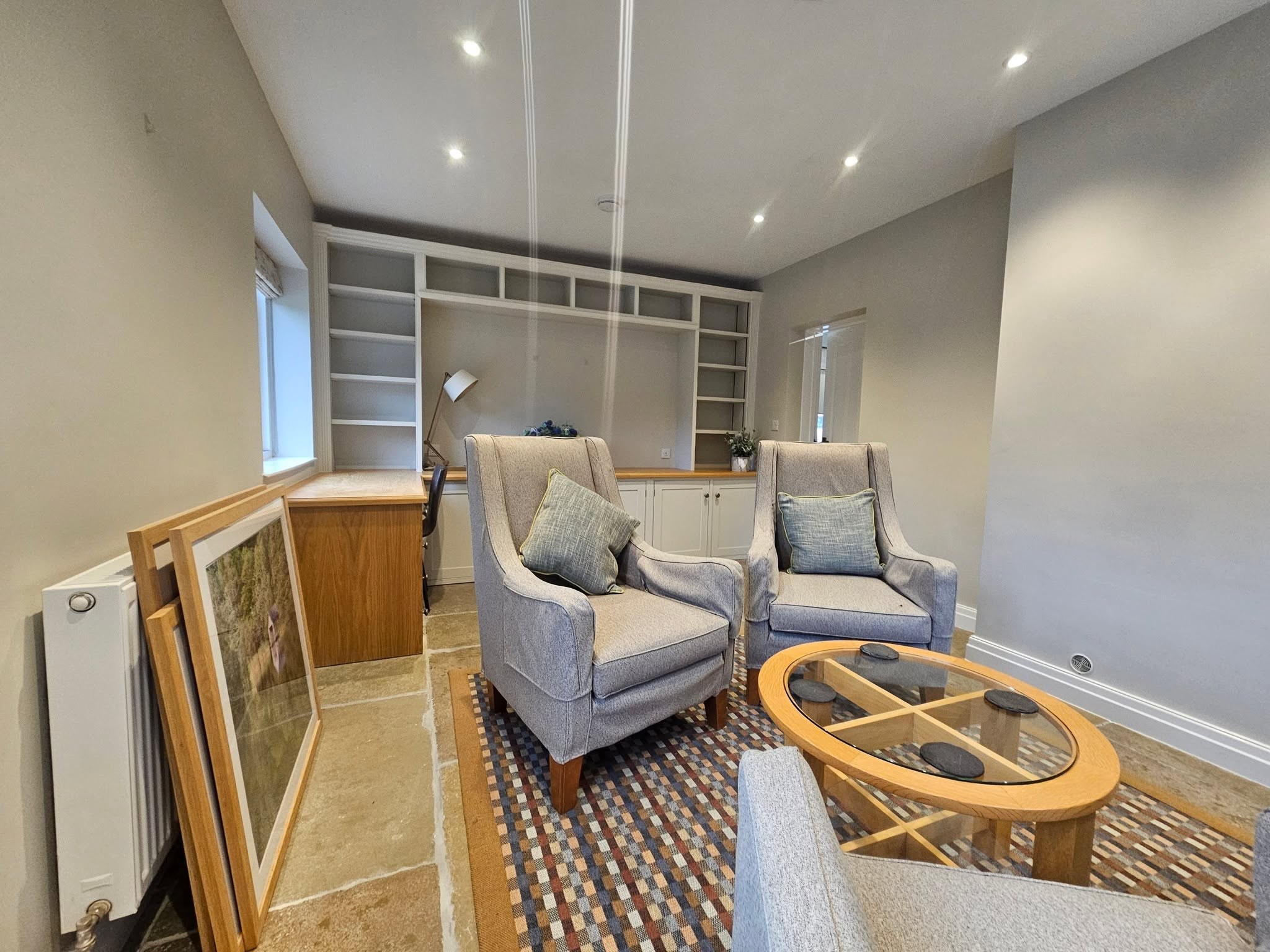 Sitting room with built-in white shelving and armchairs