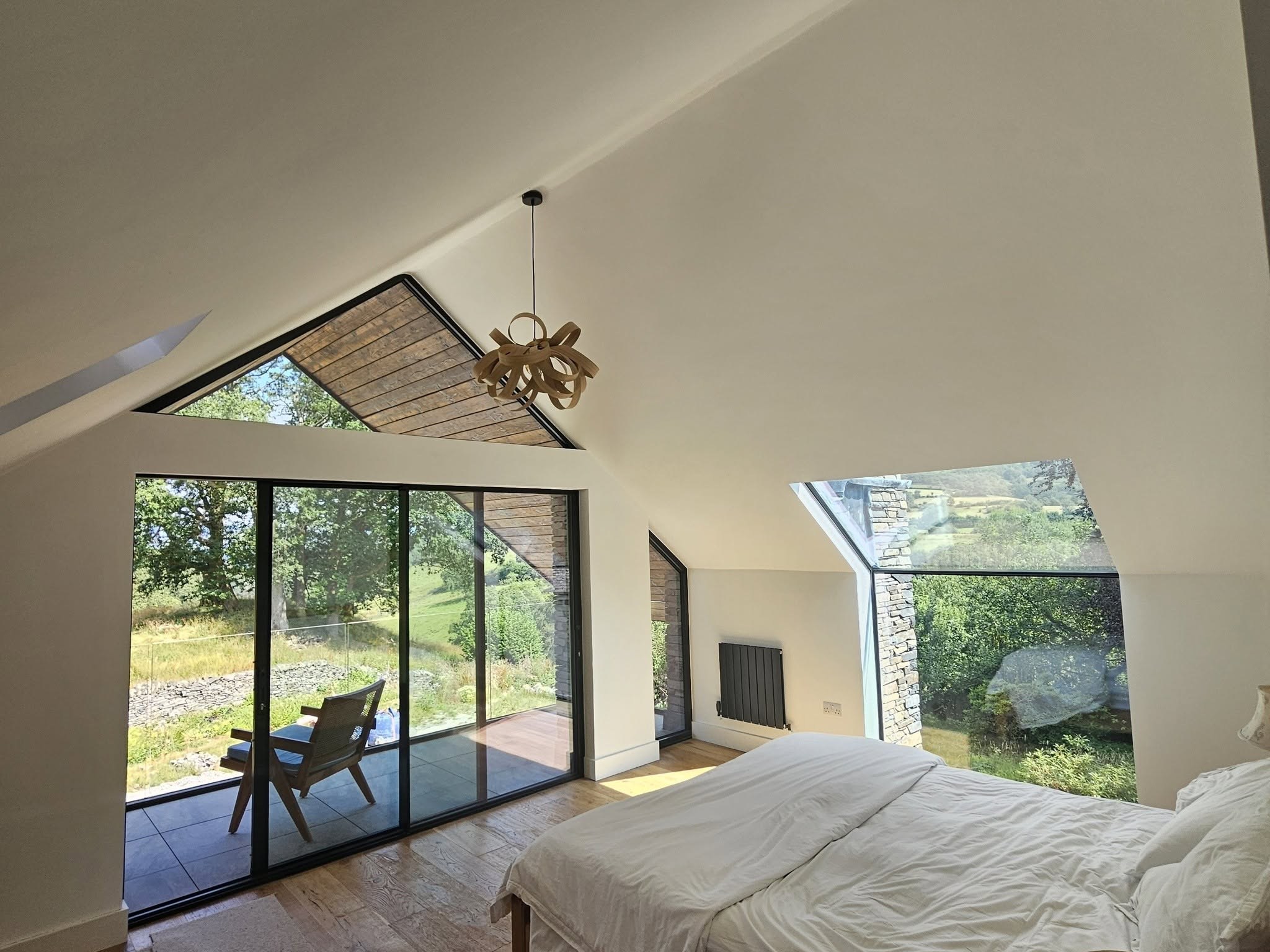 Vaulted bedroom with a glazed gable and sliding doors to the garden
