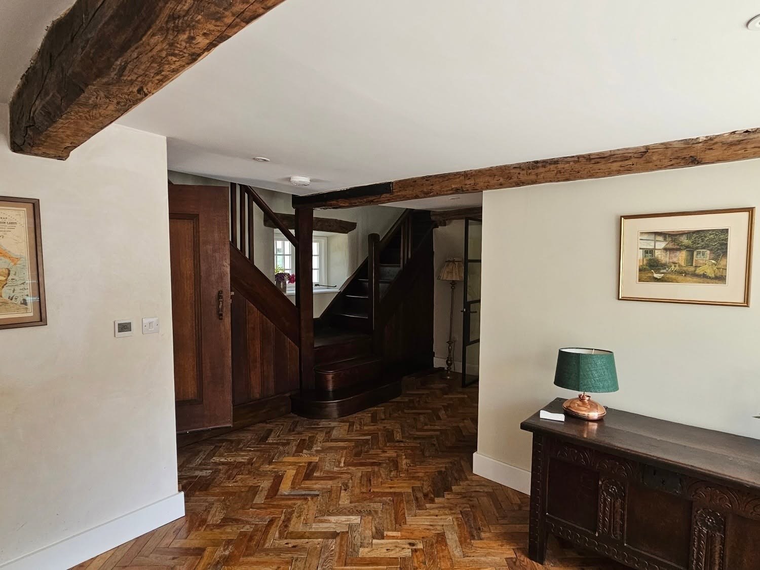 Beamed hallway with a parquet floor and dark oak staircase