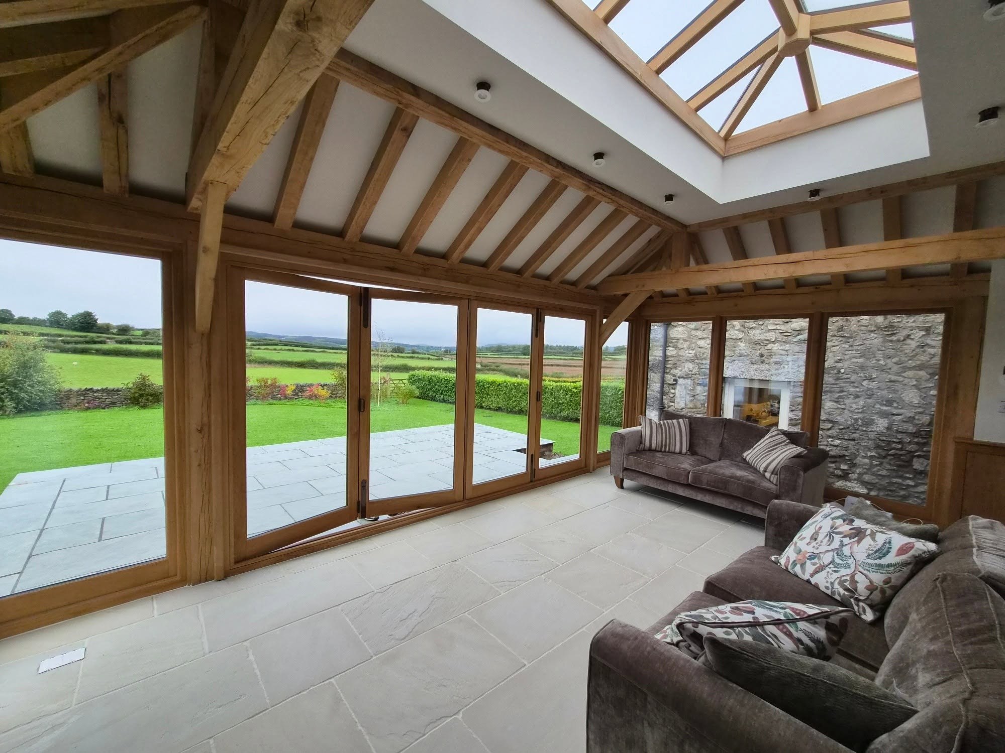 Oak-framed garden room with a lantern roof and countryside views