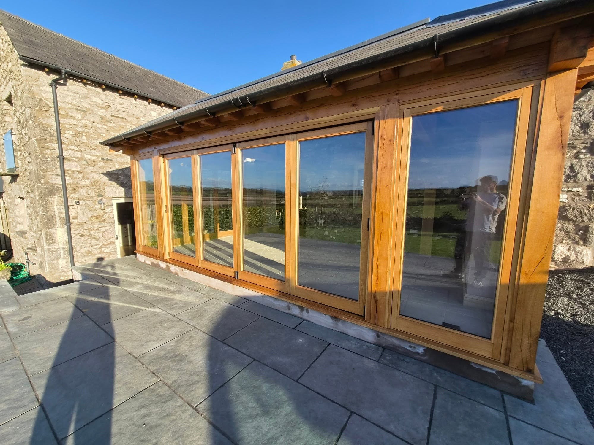 Oak-framed garden room from outside, above a flagged terrace