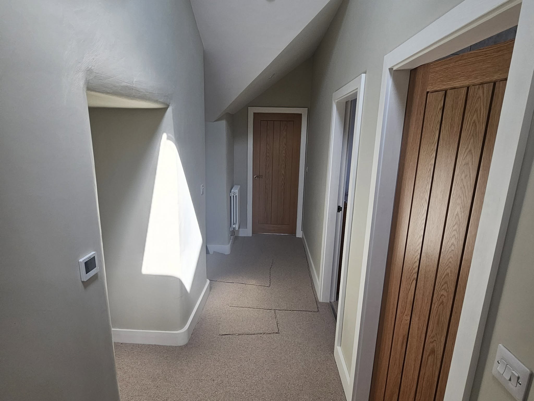 Hallway with oak plank doors and fresh pale walls