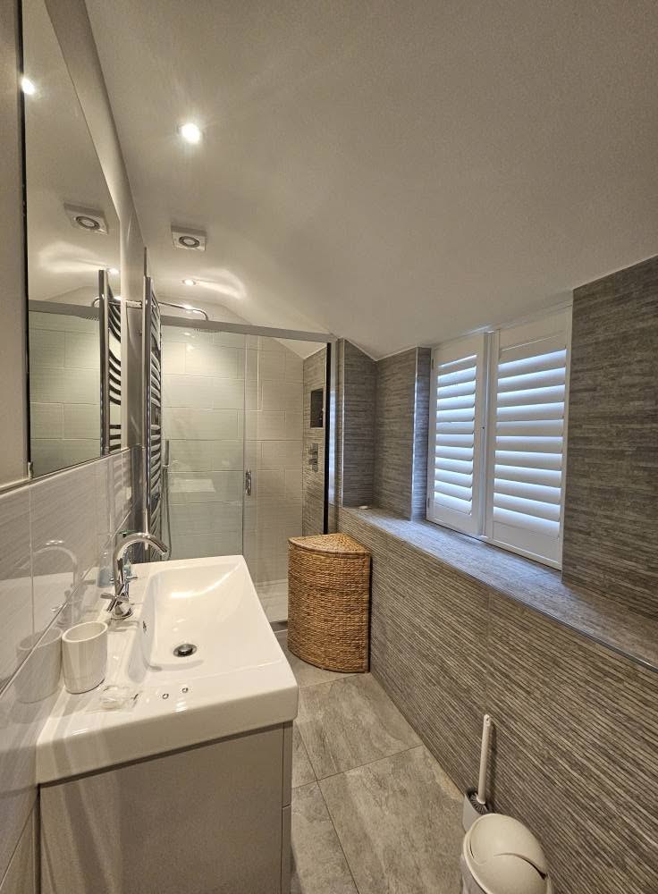 Bathroom with plantation shutters and tiled walls