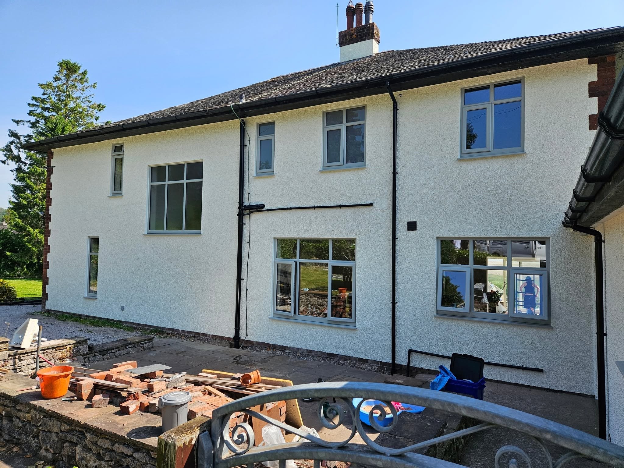 A house finished in fresh white render paint, with the patio being laid