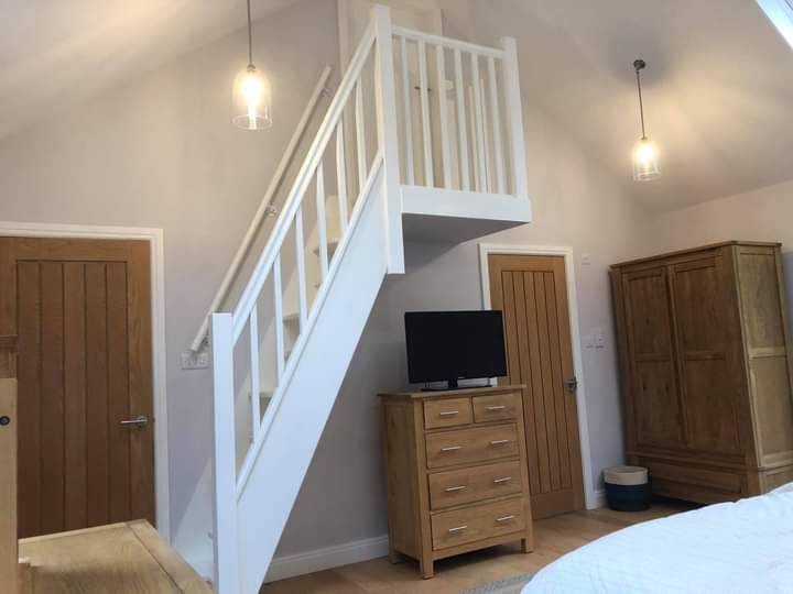 White painted open staircase in a bedroom, with oak doors