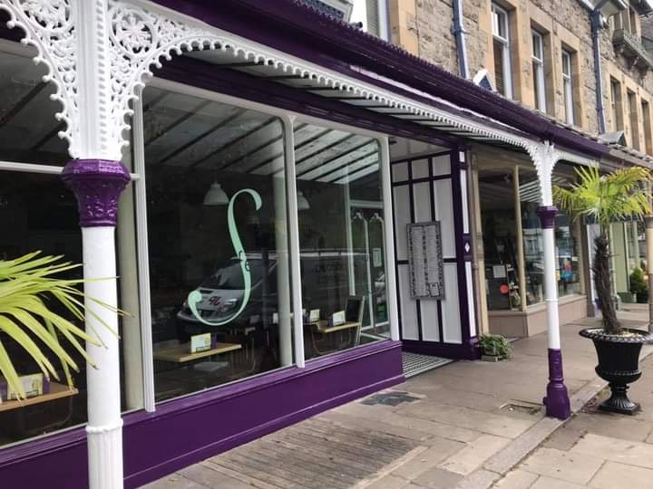 Shopfront painted deep purple with white Victorian cast-iron canopy columns