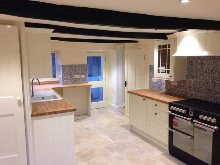 Cream shaker kitchen under black beams with a range cooker