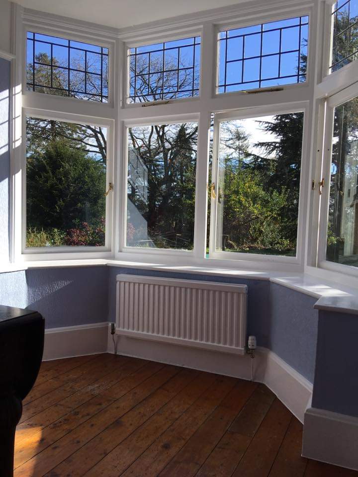 Bay window with leaded lights, white woodwork and a timber floor